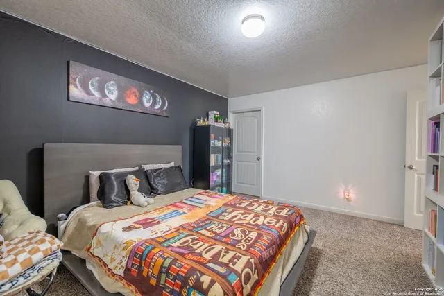 a bedroom with a large bed and a chandelier