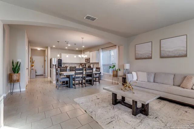 a living room with furniture and a dining table with kitchen view