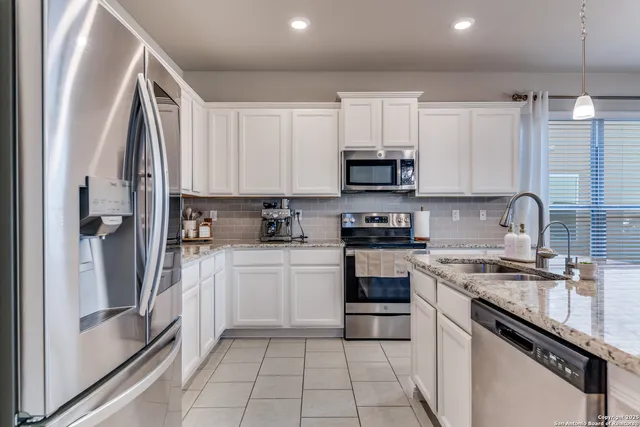 a kitchen with a sink stove and white cabinets