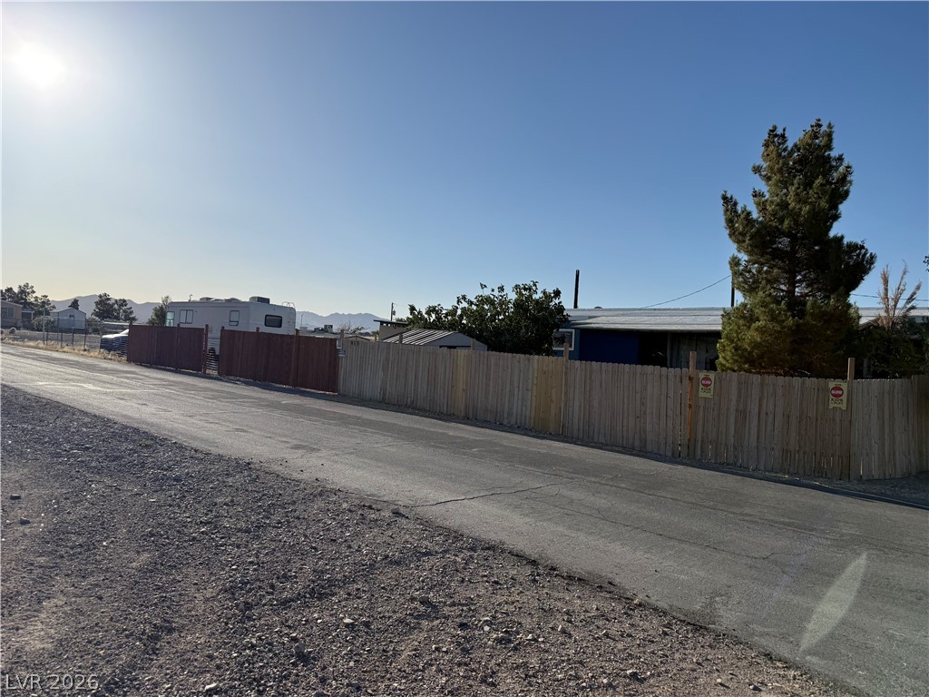 975 Sky Road Indian Springs, NV 89018 - Photo 3 of 4 A rustic wooden fence encloses a spacious yard in this sun-drenched outdoor setting.