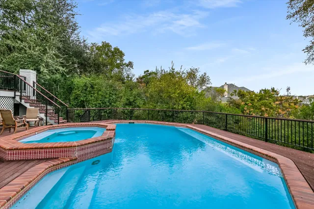 a view of a swimming pool with a patio and a yard