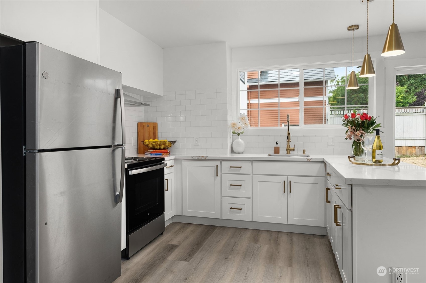 3932 South Morgan Street Seattle, WA 98118 - Photo 23 of 40 a kitchen with white cabinets and stainless steel appliances