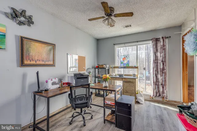 a view of a workspace with furniture and a window