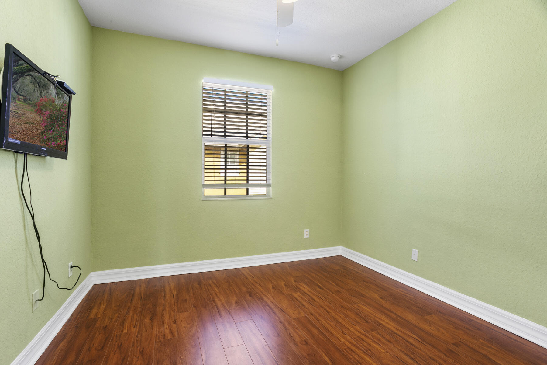 114 Locustberry Lane, Unit 101 Jupiter, FL 33458 - Photo 11 of 59 a view of empty room with wooden floor and fan