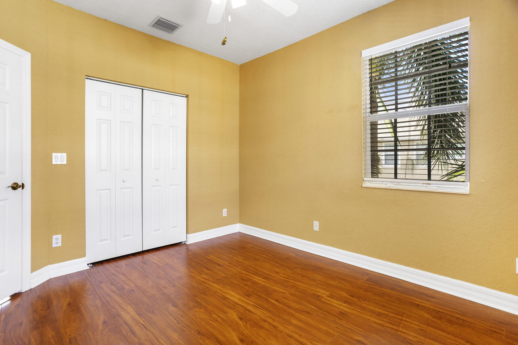 114 Locustberry Lane, Unit 101 Jupiter, FL 33458 - Photo 12 of 59 a view of an empty room with wooden floor and a window