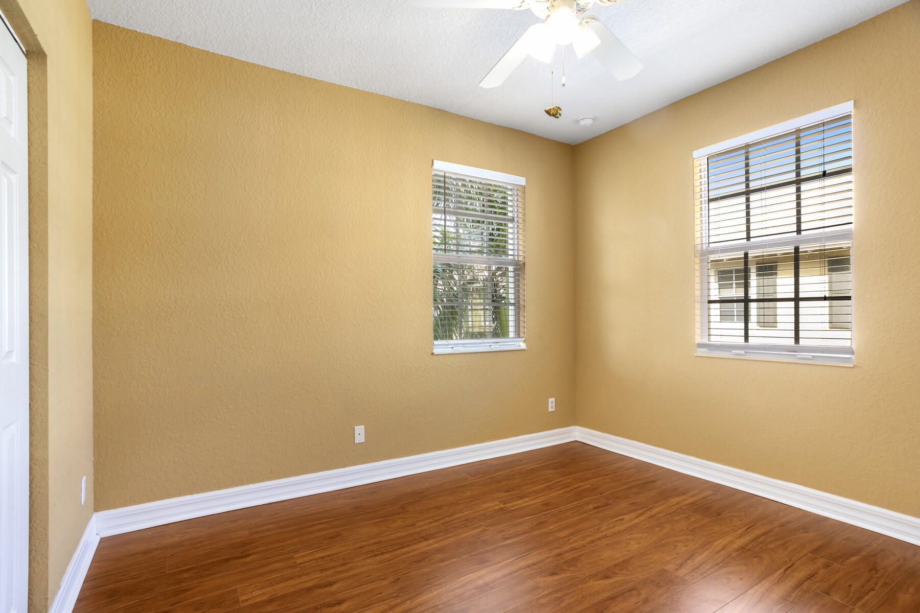 114 Locustberry Lane, Unit 101 Jupiter, FL 33458 - Photo 13 of 59 a view of an empty room with wooden floor and a window
