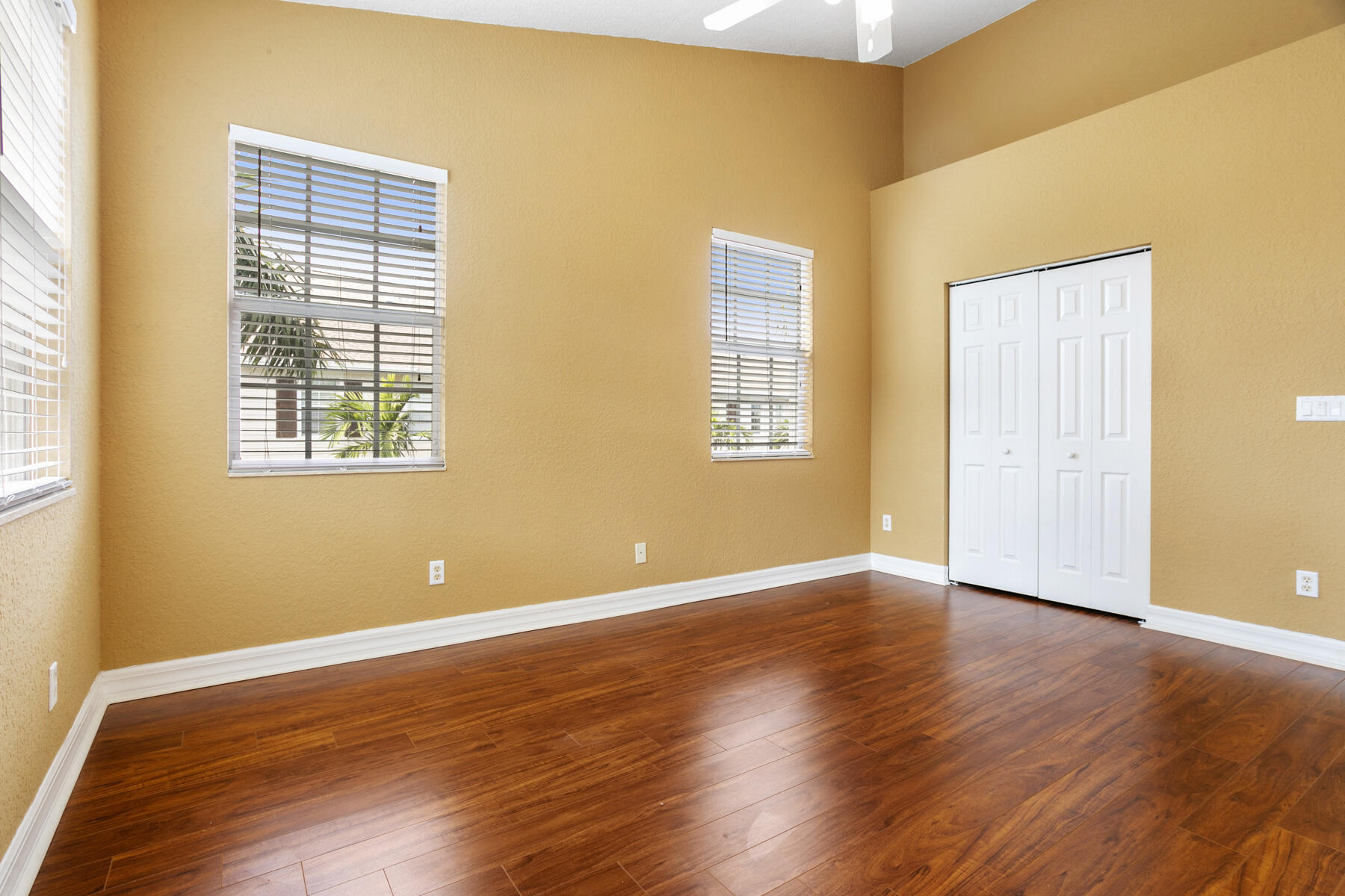 114 Locustberry Lane, Unit 101 Jupiter, FL 33458 - Photo 19 of 59 a view of an empty room with wooden floor and a window