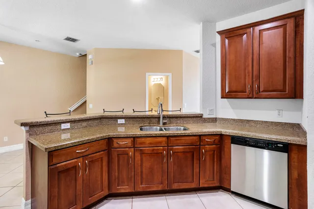 a view with granite countertop a sink and a wooden cabinets