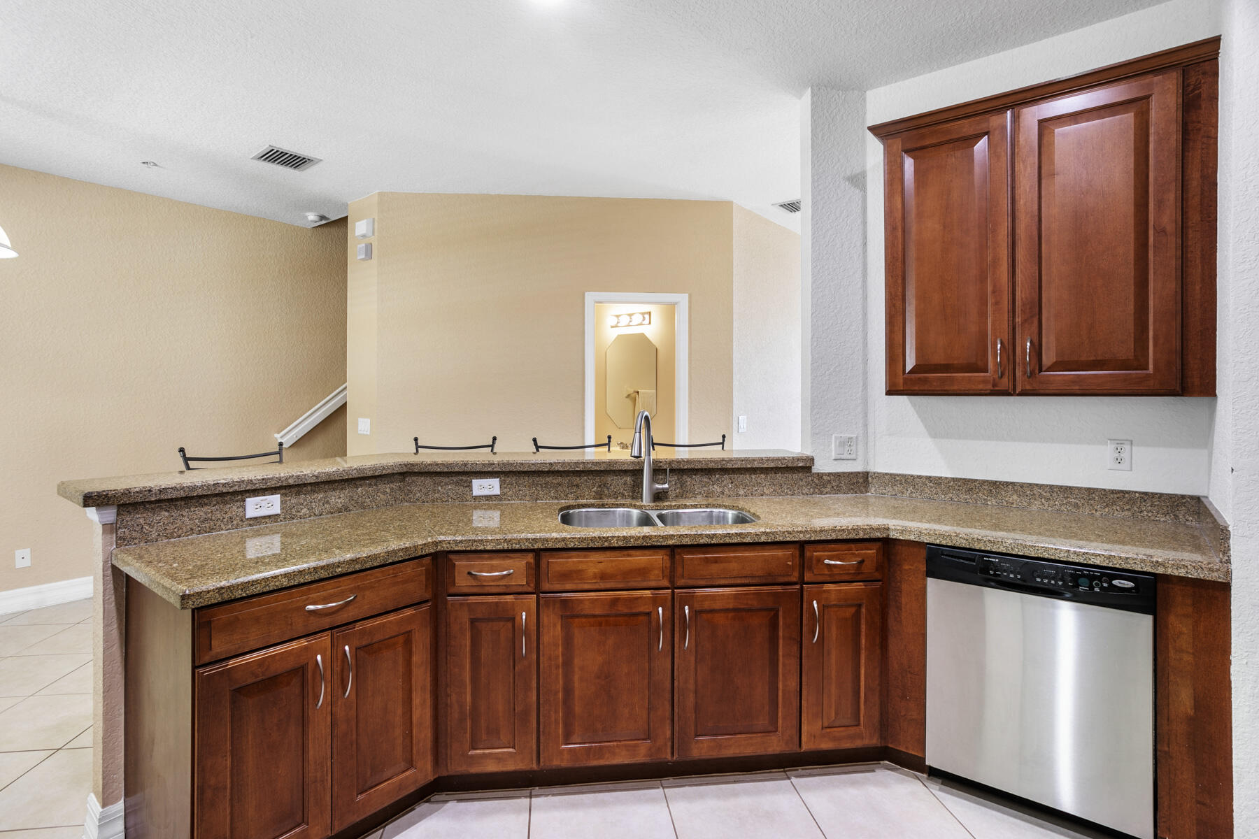 114 Locustberry Lane, Unit 101 Jupiter, FL 33458 - Photo 4 of 59 a view with granite countertop a sink and a wooden cabinets