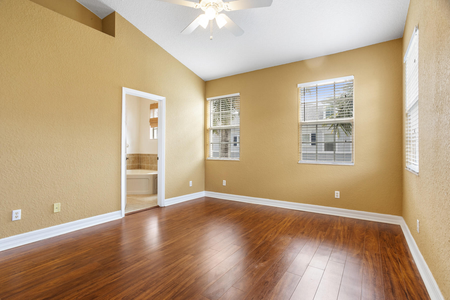114 Locustberry Lane, Unit 101 Jupiter, FL 33458 - Photo 8 of 59 a view of an empty room with wooden floor and a window
