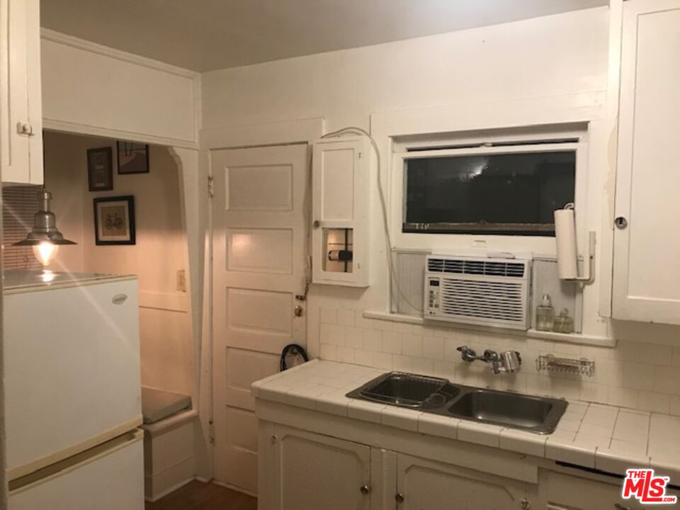 223 Strand Street, Unit G Santa Monica, CA 90405 - Photo 3 of 6 a kitchen with a sink and a refrigerator