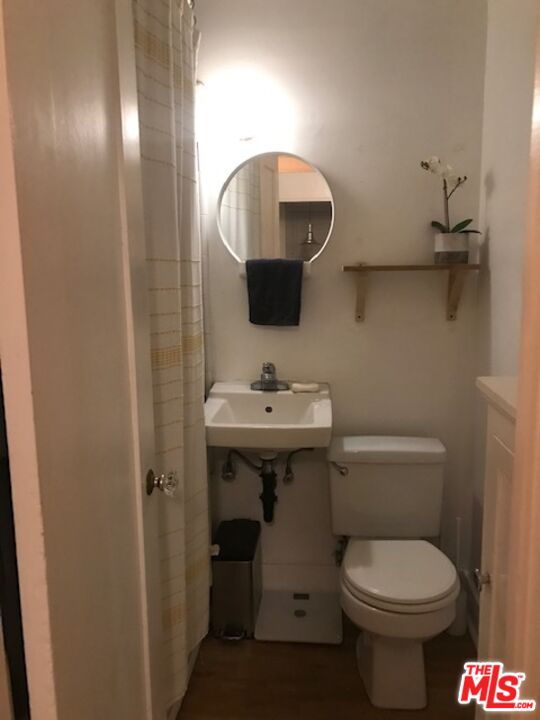 223 Strand Street, Unit G Santa Monica, CA 90405 - Photo 5 of 6 a bathroom with a toilet sink and mirror