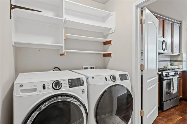 a view of washer and dryer with kitchen in the background