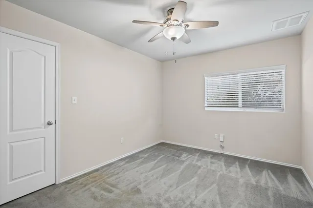 a view of empty room with ceiling fan