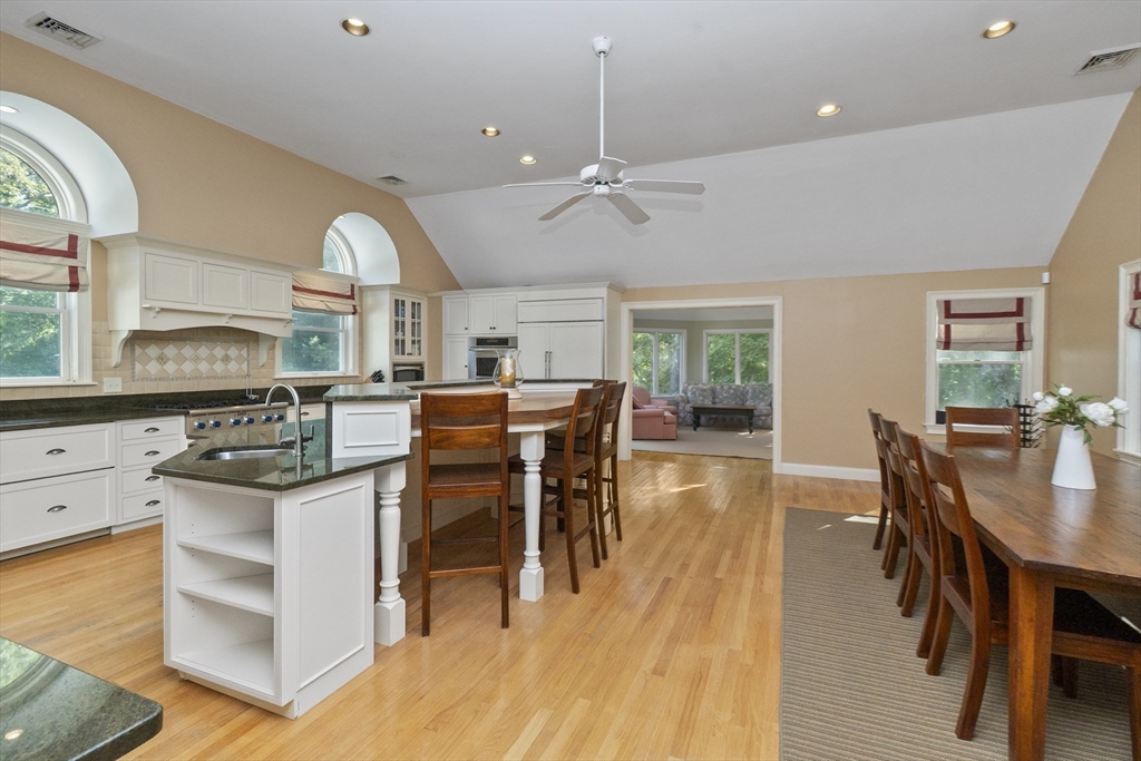 6 Heron Way Mashpee, MA 02649 - Photo 11 of 42 a kitchen with stainless steel appliances kitchen island granite countertop a stove a refrigerator a dining table and chairs with wooden floor