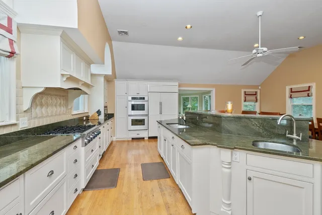 a large kitchen with a counter space a sink and stainless steel appliances