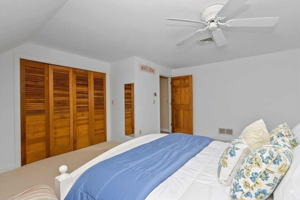 6 Heron Way Mashpee, MA 02649 - Photo 30 of 42 a bedroom with a large bed and a chandelier