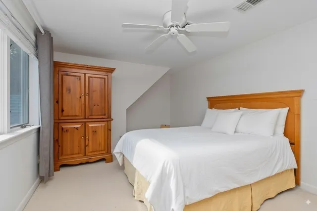 a bedroom with a bed and a refrigerator