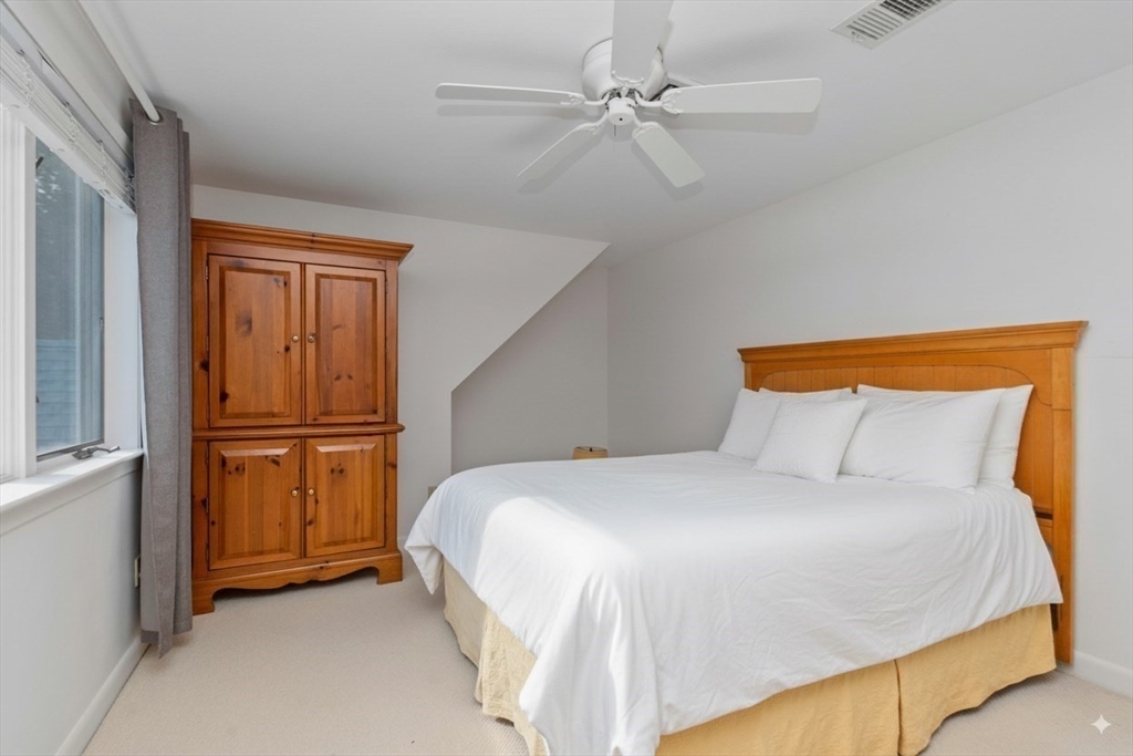 6 Heron Way Mashpee, MA 02649 - Photo 32 of 42 a bedroom with a bed and a refrigerator