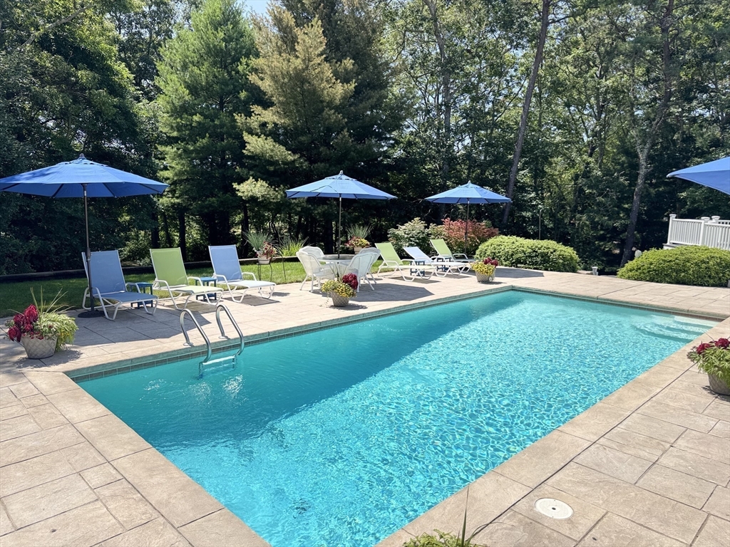 6 Heron Way Mashpee, MA 02649 - Photo 38 of 42 a patio with a table and chairs under an umbrella