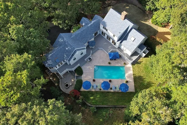 a kitchen with stainless steel appliances kitchen island granite countertop a stove top oven a sink a dining table and chairs with wooden floor