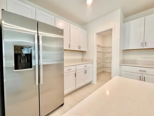 a kitchen with a refrigerator stove and white cabinets
