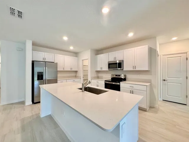 a kitchen with white cabinets and stainless steel appliances