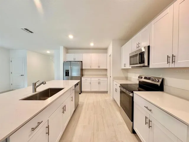 a kitchen with granite countertop sink stainless steel appliances and cabinets