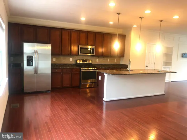 a kitchen with stainless steel appliances granite countertop a stove a sink and a refrigerator