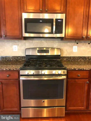 a stove top oven sitting inside of a kitchen