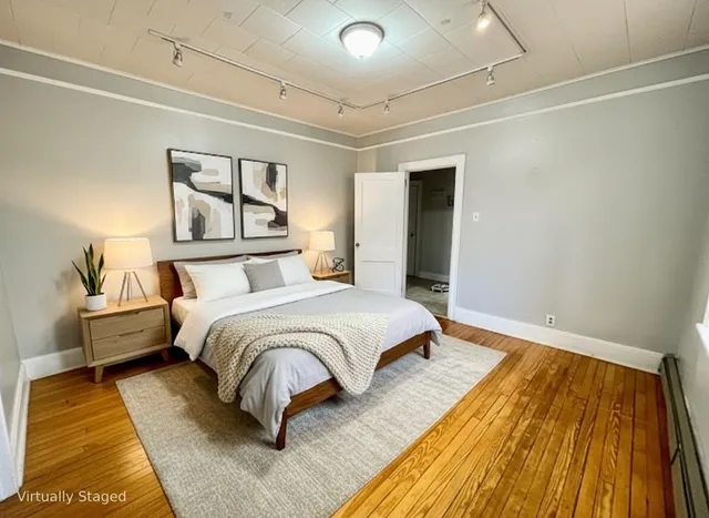 a bedroom with a bed and wooden floor