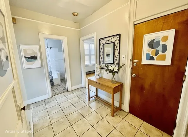 a view of a hallway with wooden floor and a bathroom