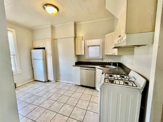 a kitchen with a stove a refrigerator and cabinets