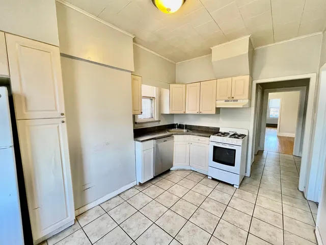 a kitchen with a refrigerator sink and cabinets
