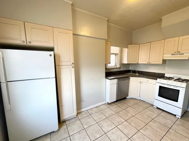 a white refrigerator freezer and a stove sitting inside of a kitchen