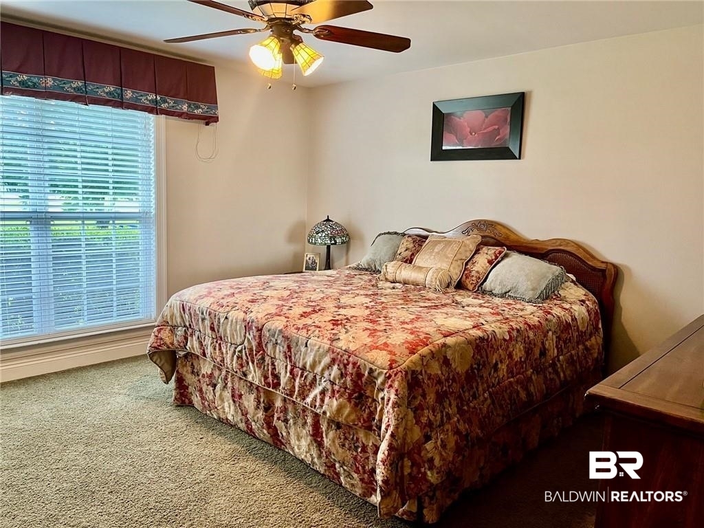 16311 Old Brady Road Bay Minette, AL 36507 - Photo 26 of 38 Carpeted bedroom featuring a large window with blinds and valance, a ceiling fan with integrated lighting, and neutral wall tones