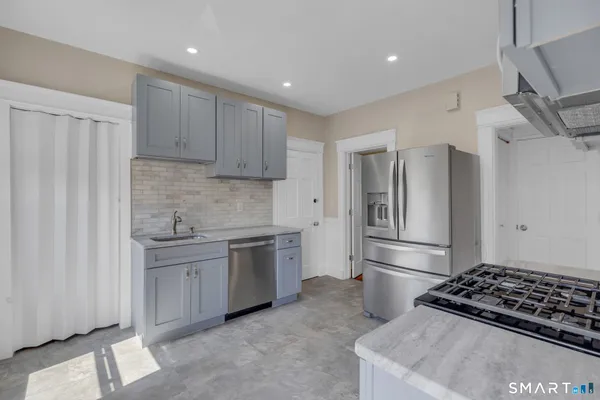 a kitchen with stainless steel appliances granite countertop a refrigerator and a sink