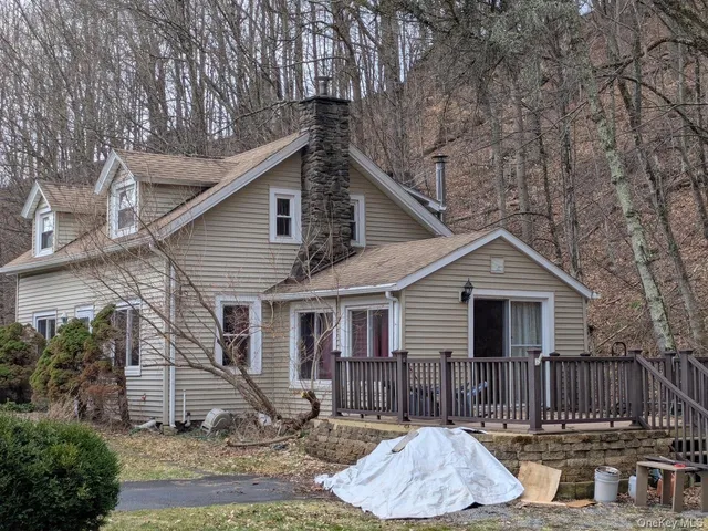a view of a house with a yard chairs and wooden fence