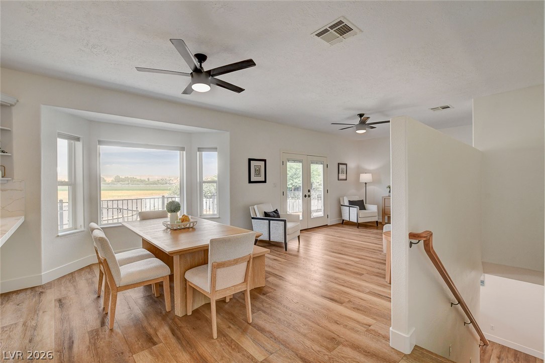 4362 Thistle Street Logandale, NV 89021 - Photo 16 of 99 Natural light floods this dining area, featuring a bay window with scenic field views and direct outdoor access.