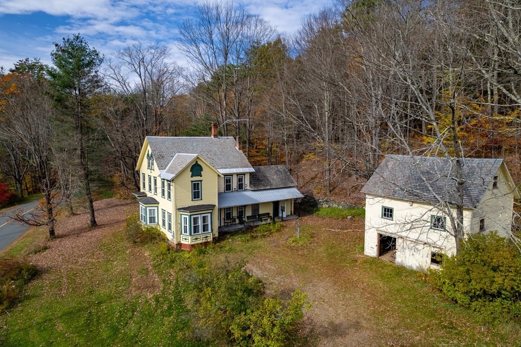 an aerial view of a house with a big yard and large trees