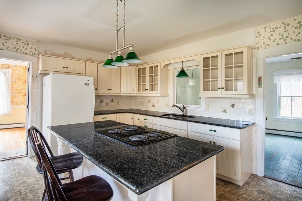 16 Hazelton Road Rowe, MA 01367 - Photo 17 of 33 a kitchen with a stove a sink a refrigerator and wooden cabinets