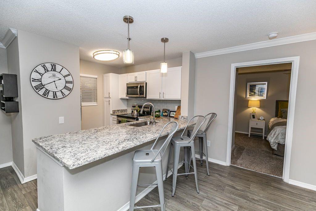 1401 West Paces Ferry Road Northwest, Unit 1303 Atlanta, GA 30327 - Photo 2 of 33 a view of a kitchen with a dining table and chairs
