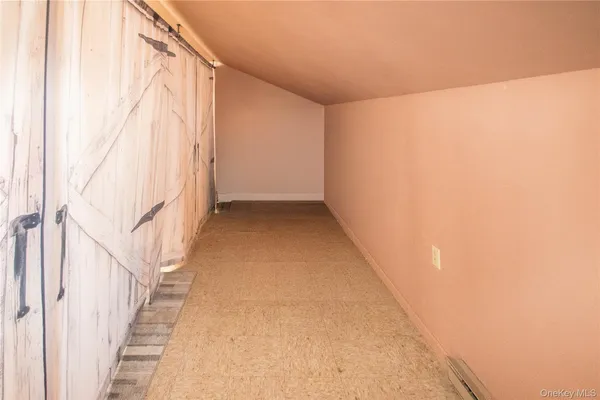 a view of a big room with wooden floor and windows