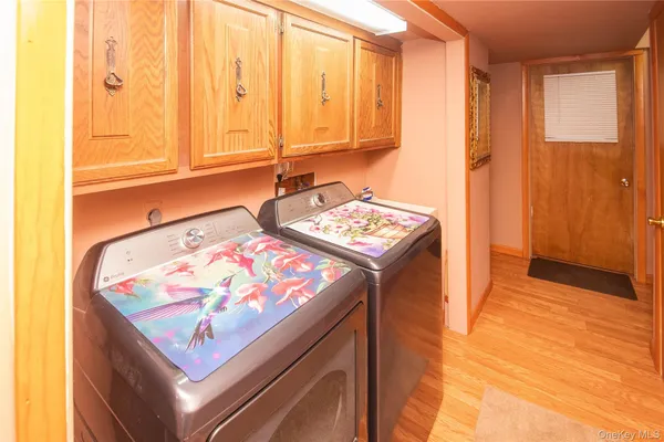 a view of kitchen island with stainless steel appliances wooden floor and window