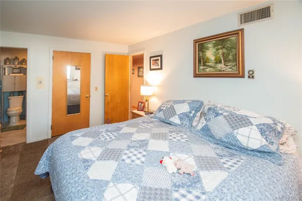 a bedroom with a large bed and wooden floor