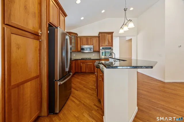 a kitchen with stainless steel appliances granite countertop a refrigerator and a sink