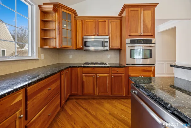 a kitchen with stainless steel appliances granite countertop a stove a sink and a microwave