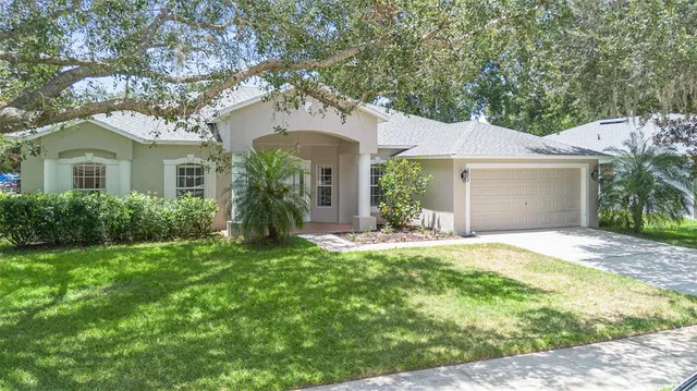 an aerial view of residential houses with outdoor space and trees