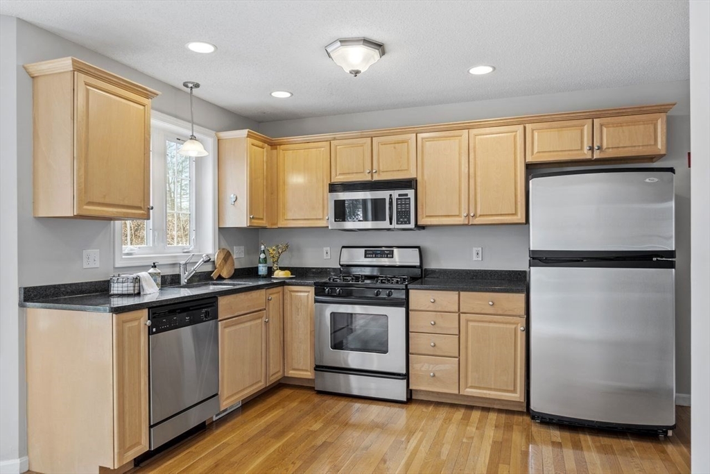 181 High Street, Unit 2 Andover, MA 01810 - Photo 2 of 32 a kitchen with a white cabinets and wooden floor