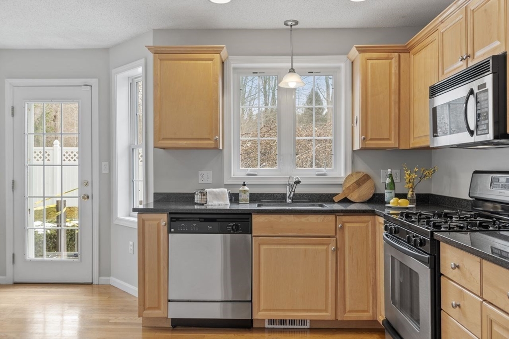 181 High Street, Unit 2 Andover, MA 01810 - Photo 3 of 32 a kitchen with stainless steel appliances granite countertop a sink stove and cabinets